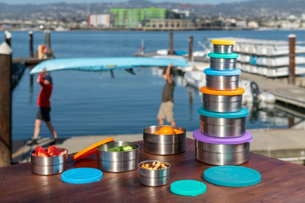 a wooden table topped with metal containers filled with food
