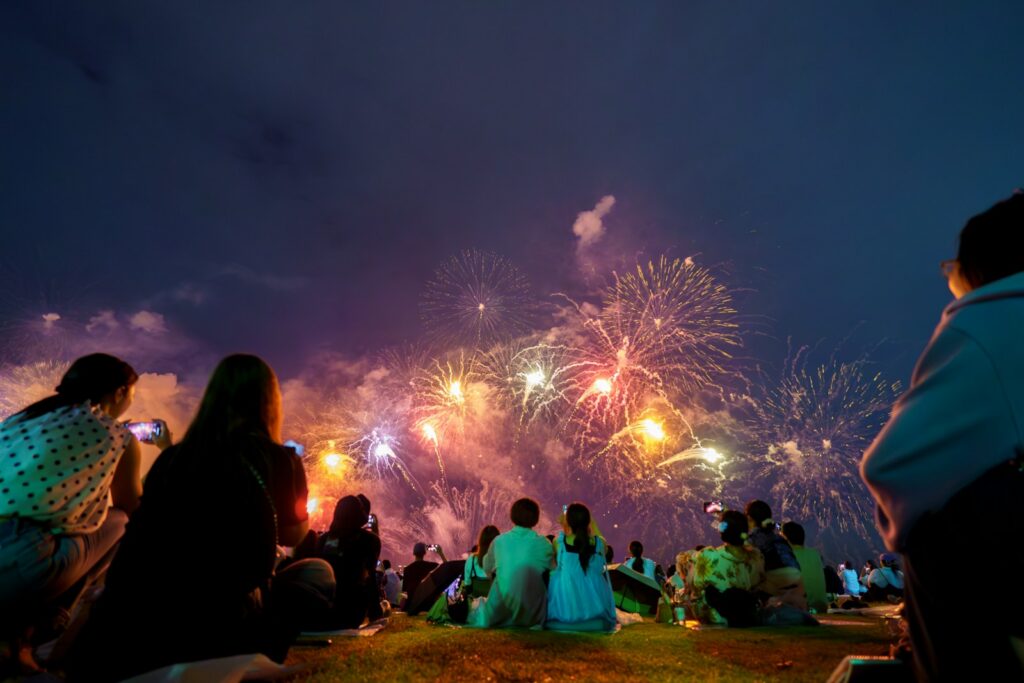 Crowd watches colorful fireworks display at night