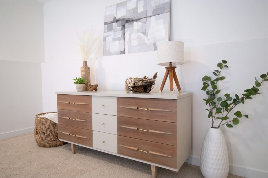 A white vase sitting on top of a wooden dresser