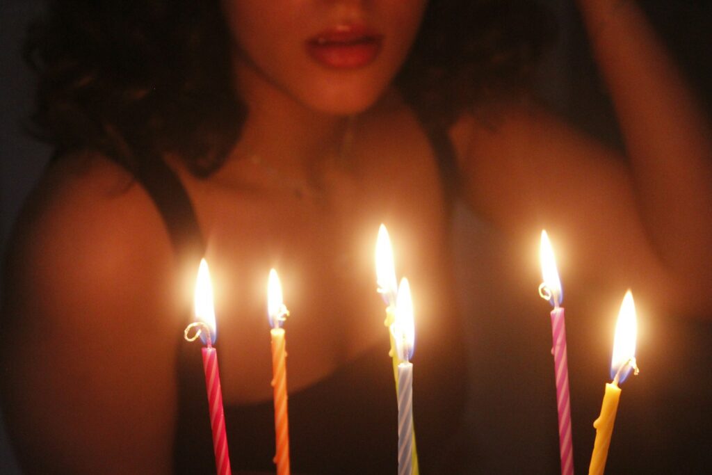A woman blowing out candles on a cake