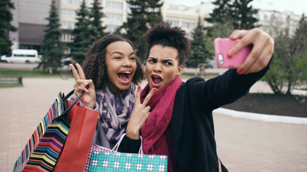 Two women taking a selfie with shopping bags