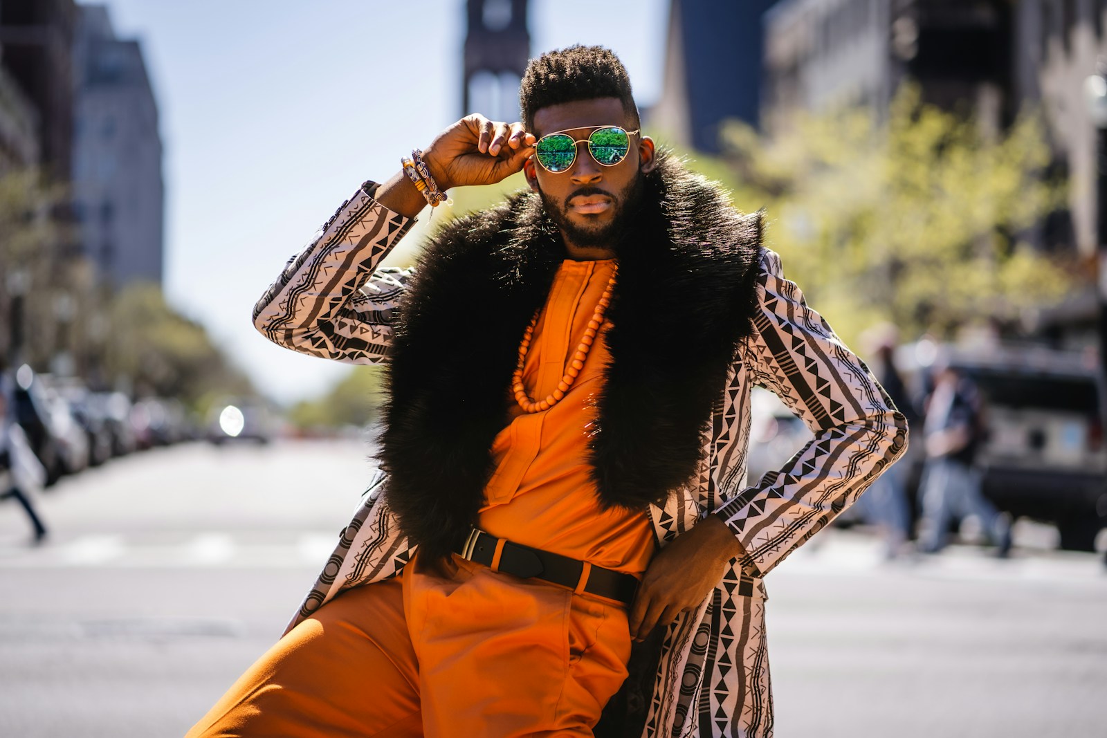 a man wearing an orange outfit and a fur vest