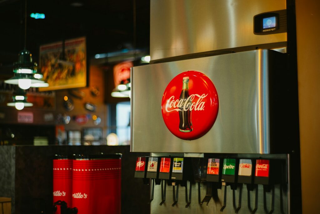 A coca cola machine sitting inside of a restaurant