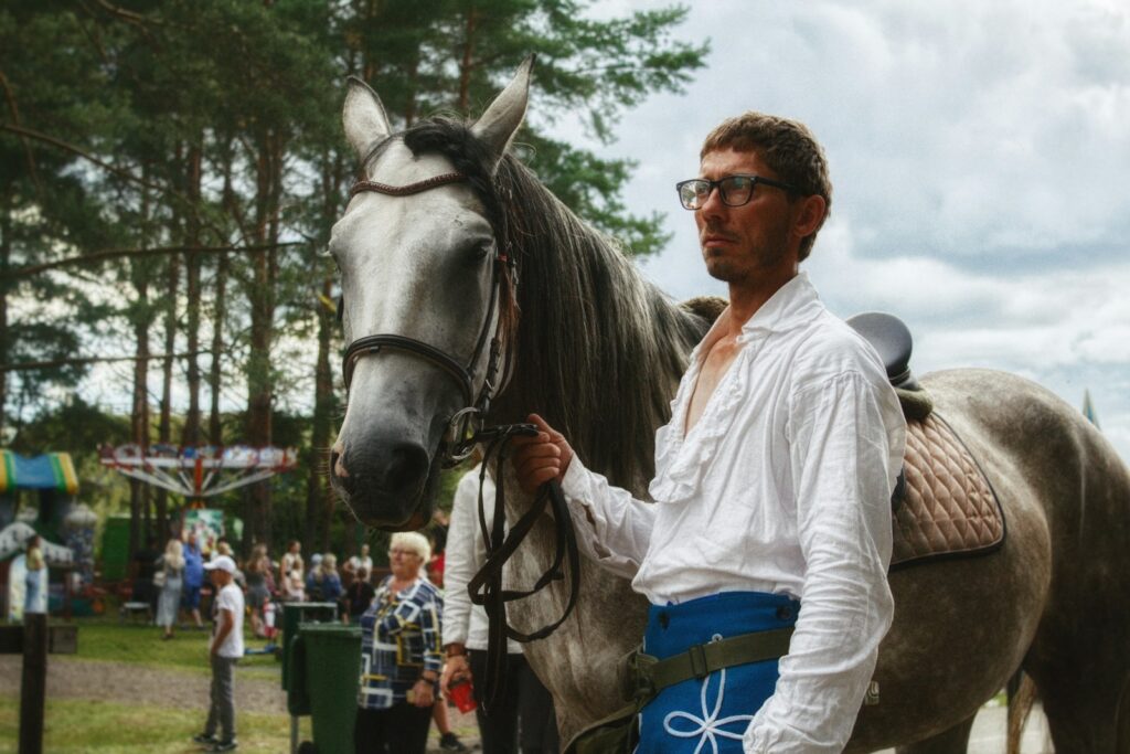 a man standing next to a brown horse