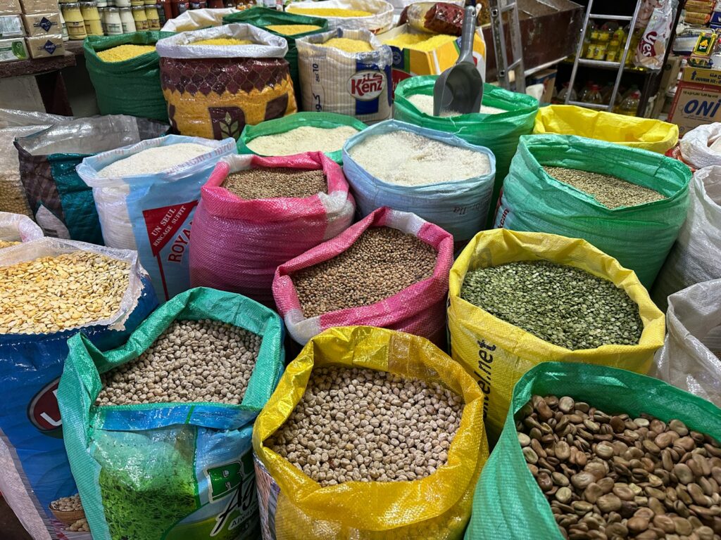 Colorful bags of grains and legumes at a market.