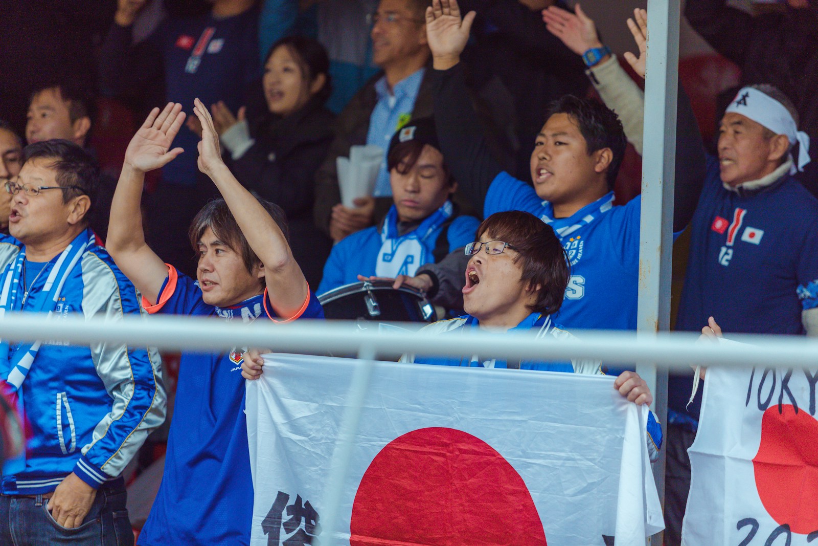 a group of young men holding up a Japanese flag