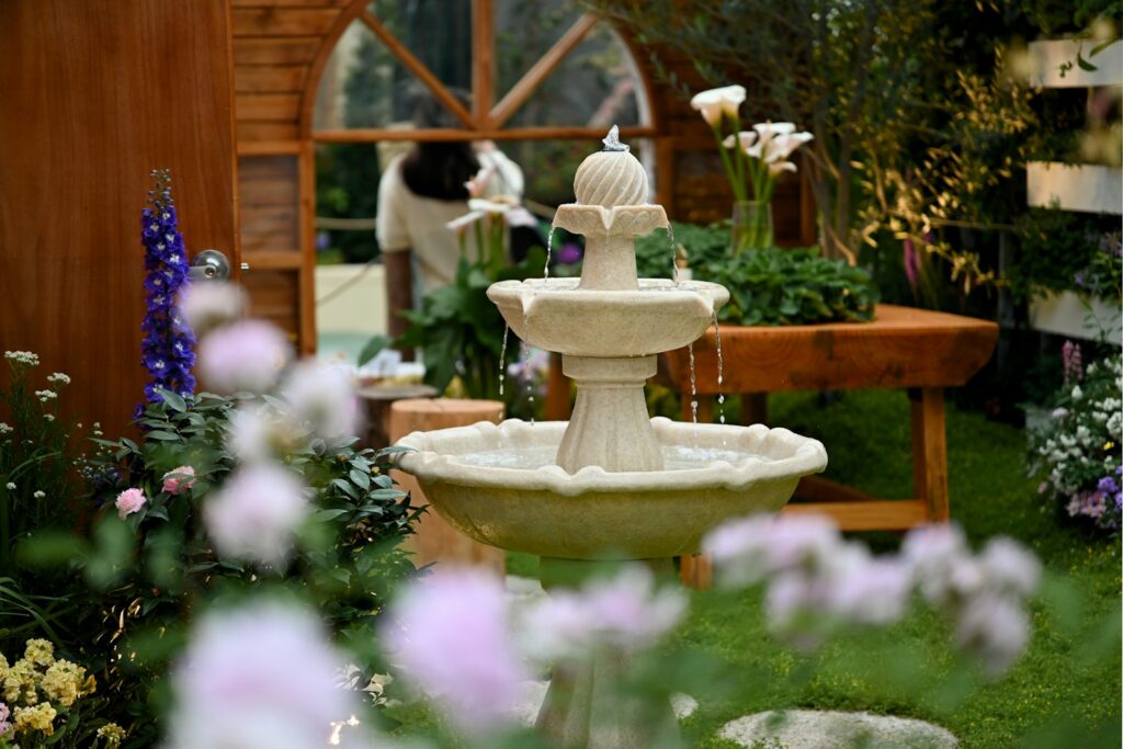 A decorative tiered fountain in a garden setting.