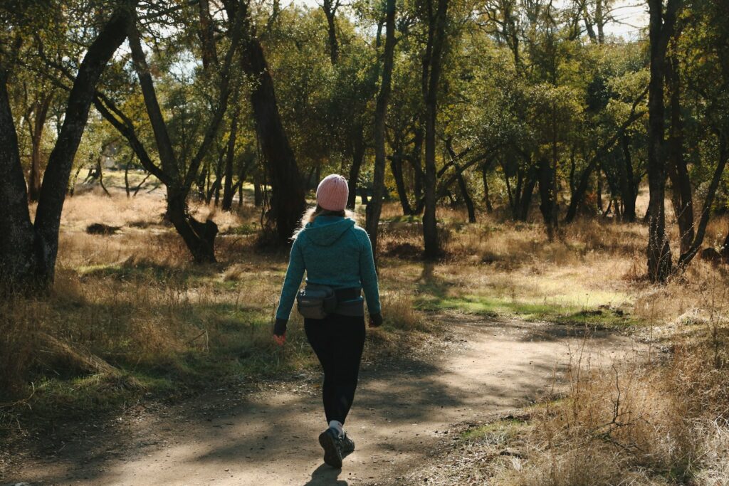 A woman is walking down a path in the woods