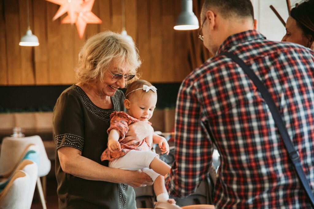 Grandparent helping father care for baby