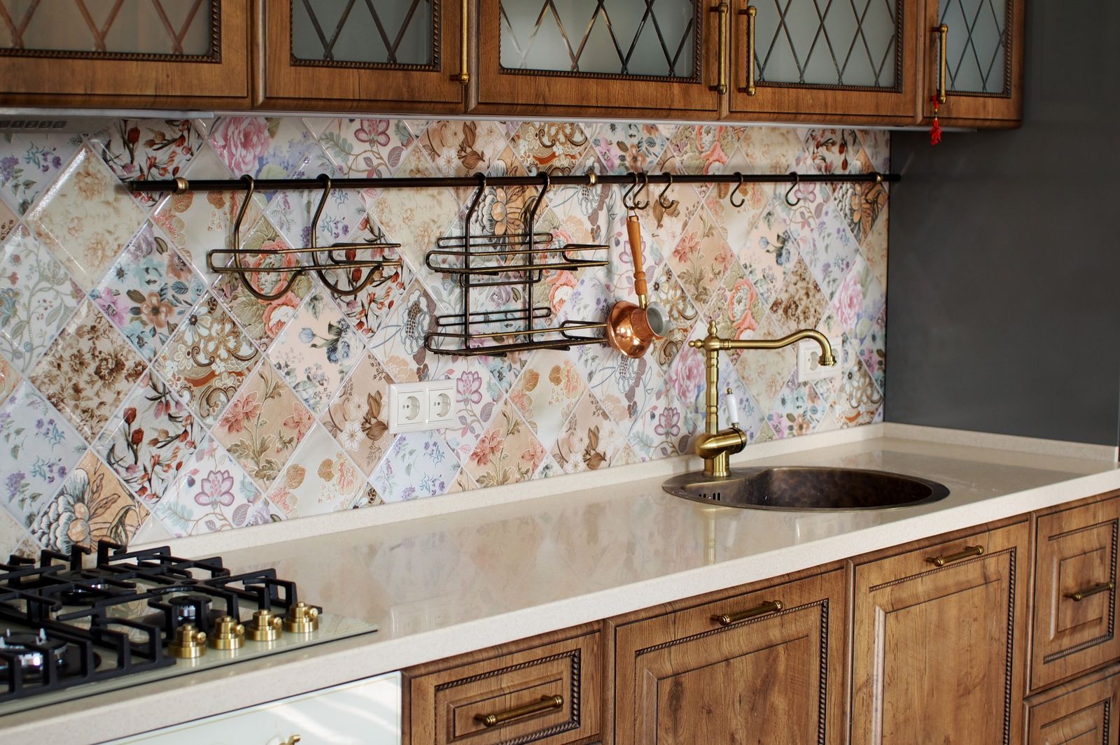 Elegant kitchen interior featuring wooden cabinets and vintage inspired floral tile backsplash.