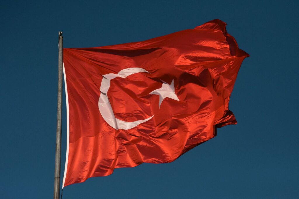 High-resolution image of the Turkish national flag waving against a clear blue sky in Istanbul.