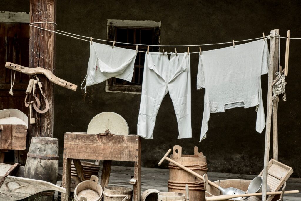 Rustic outdoor scene with vintage laundry tools and clothes hanging on a line.