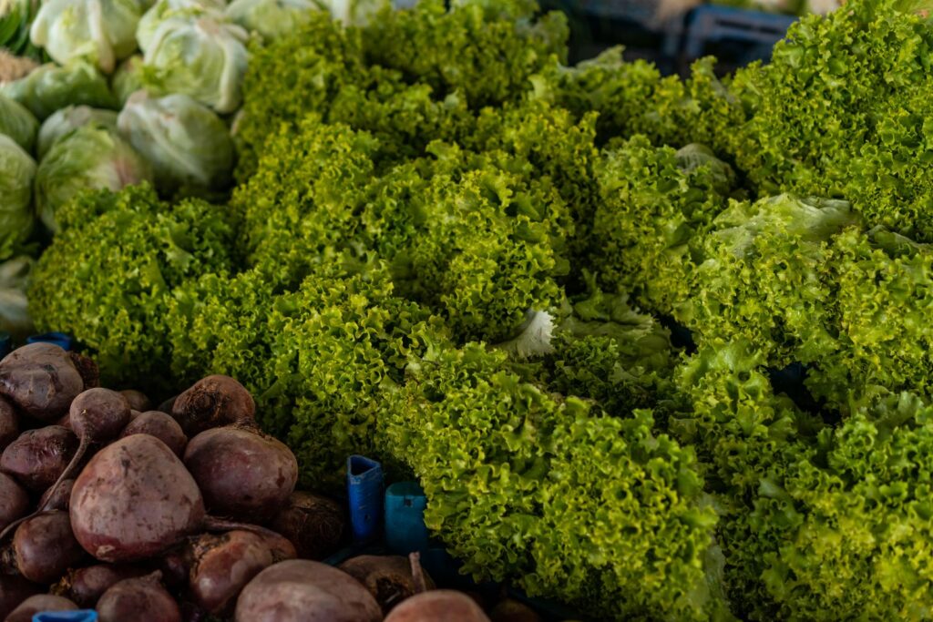 Close-up of various fresh vegetables including lettuce and beets at a market.
