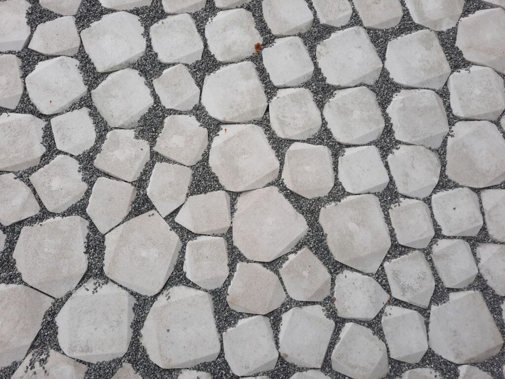 Top view of a geometric stone pathway with white rocks and gravel.