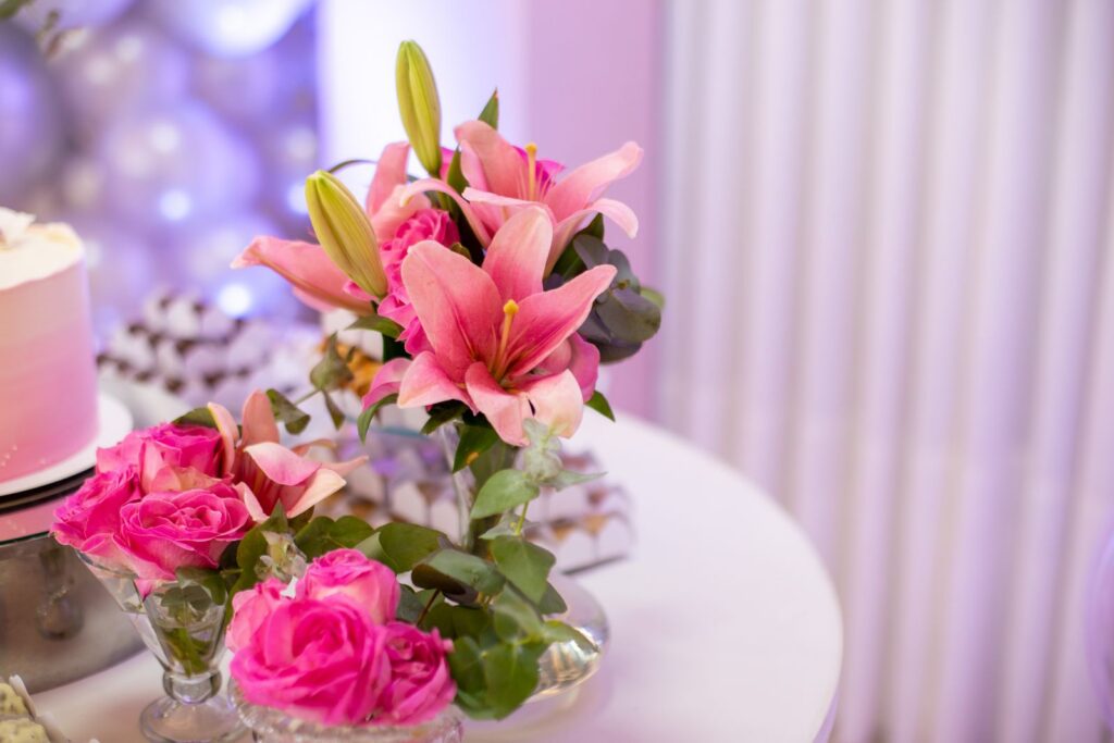 Delicate pink lilies and roses elegantly arranged on a table, perfect for decor and celebrations.
