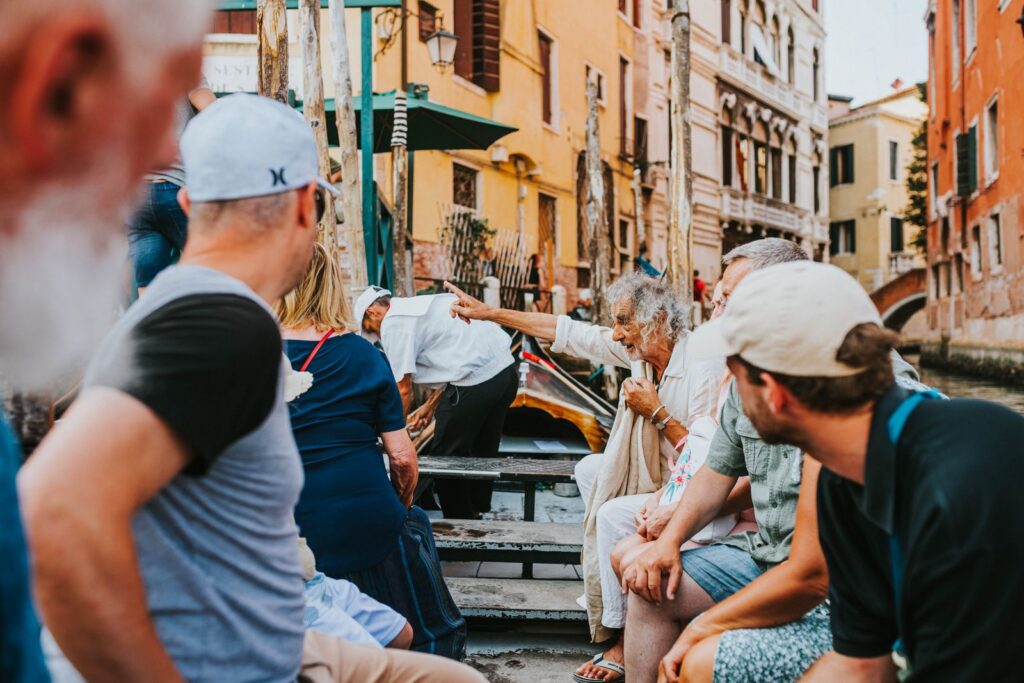 Group of diverse people interacting beside a canal in Venice, Italy.