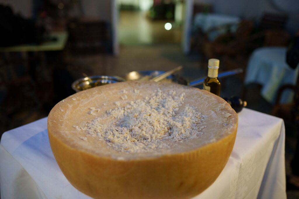 Close-up of a parmesan cheese wheel being prepared, perfect for food photography.