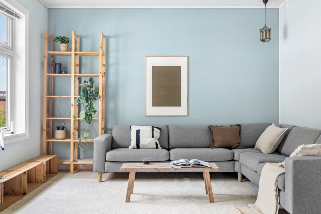 A cozy Scandinavian living room with modern gray couch and wooden elements.