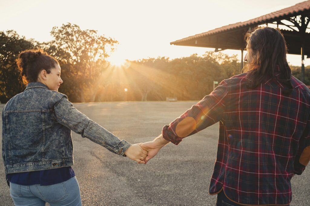 a man and a woman holding hands in a parking lot