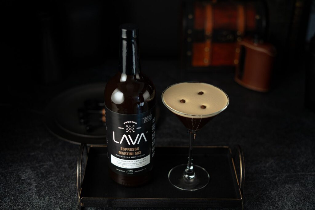 Espresso martini served in a martini glass with espresso martini mix bottle on a tray. Perfect for cocktail lovers.