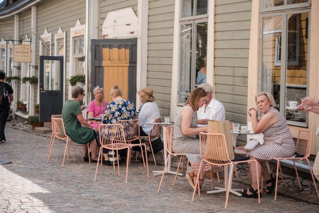 People enjoying a meal outdoors at a charming café in Porvoo, Finland.