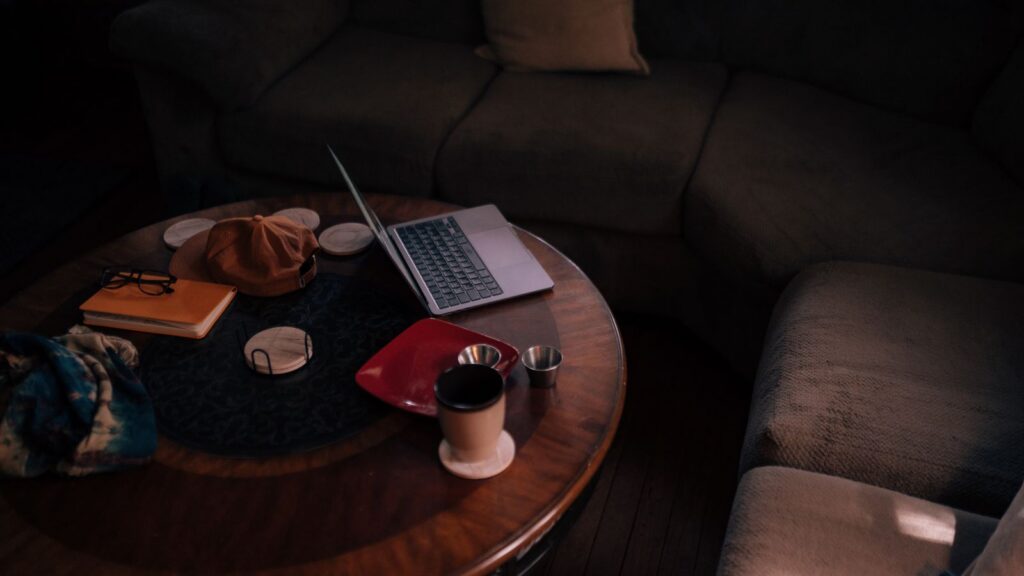 A warm, inviting living room featuring a laptop, coffee, and casual accessories.