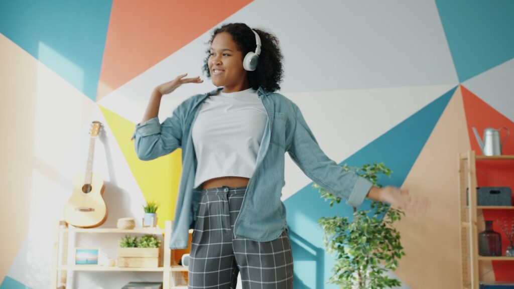 Young woman dancing with headphones on