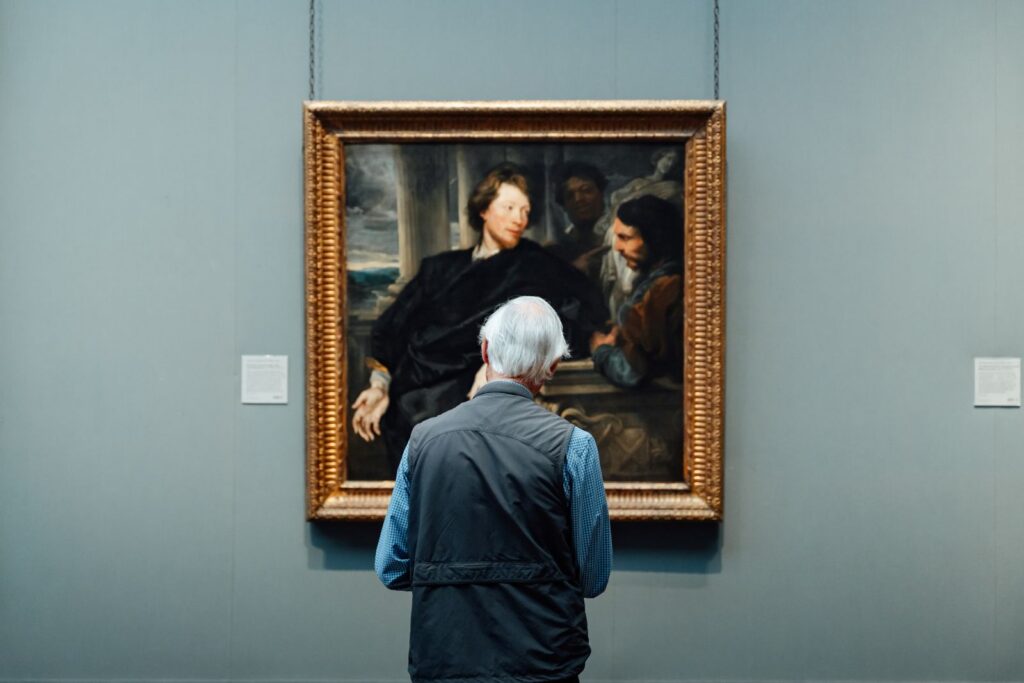 Senior admiring a classic painting in an English art gallery. Engrossed in art appreciation.