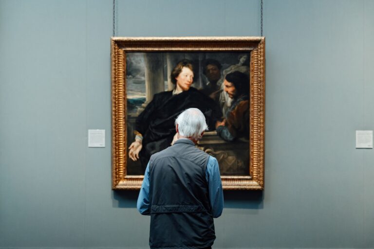 Senior admiring a classic painting in an English art gallery. Engrossed in art appreciation.