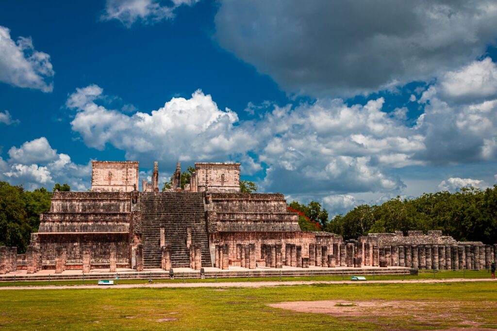 Explore the iconic Mayan ruins of Chichén Itzá in Yucatán, Mexico under a vibrant blue sky.