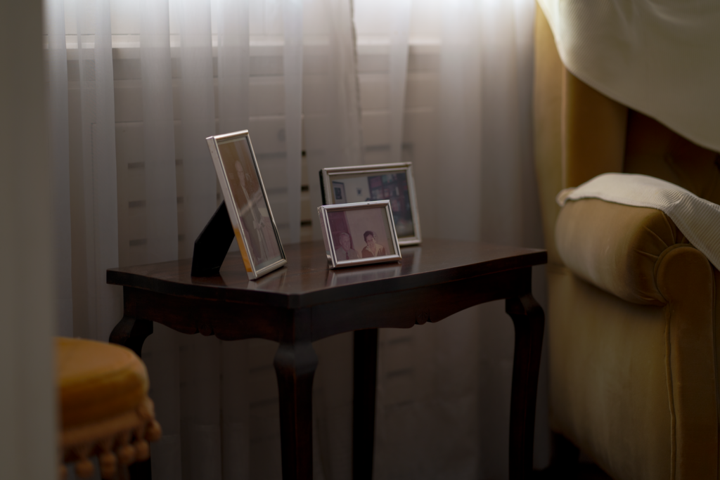 A warm, inviting corner with framed photos on a table near a window.