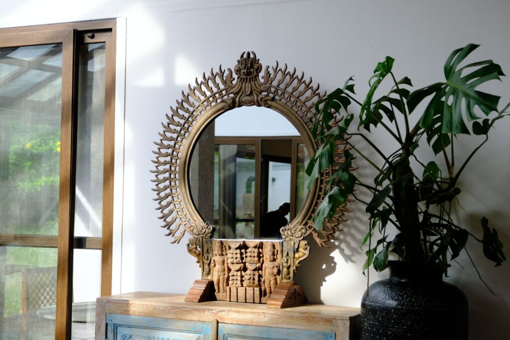 Decorative mirror with intricate design and houseplant in Nandi Hills setting.