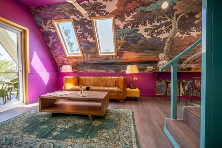 Vibrant living room featuring colorful wallpaper, skylights, and modern decor.