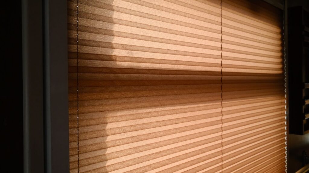 Sunlight streaming through blinds creating warm shadows in a room.