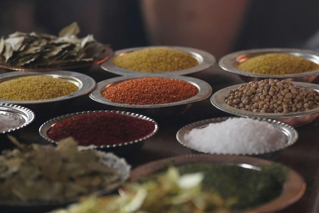 Close-up of assorted spices and grains in metal bowls showcasing culinary variety.