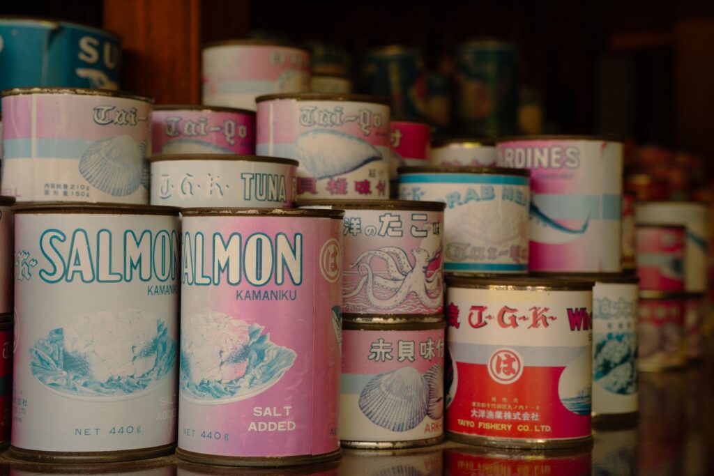 Vintage cans of Japanese seafood including salmon and tuna, displayed in a Tokyo shop.