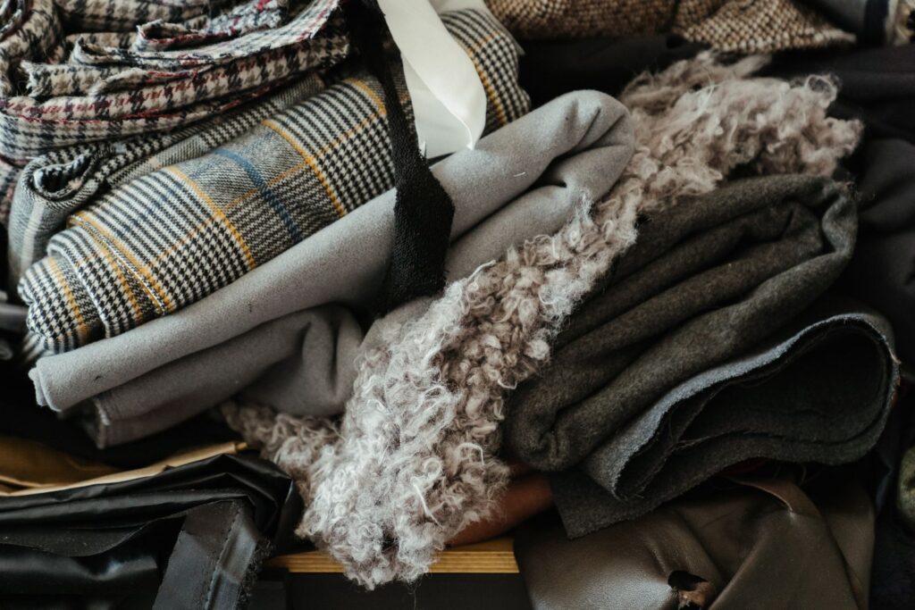Close-up of assorted colorful fabrics and textiles folded in a workshop setting.
