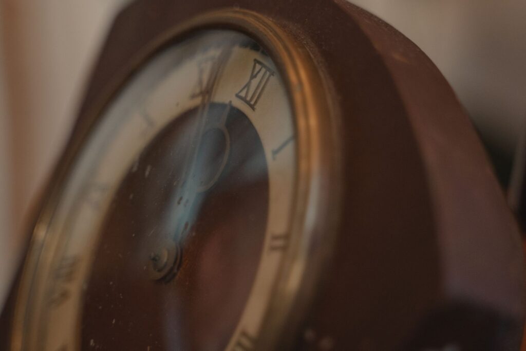 Artistic close-up of an antique clock face showcasing Roman numerals and weathered details.