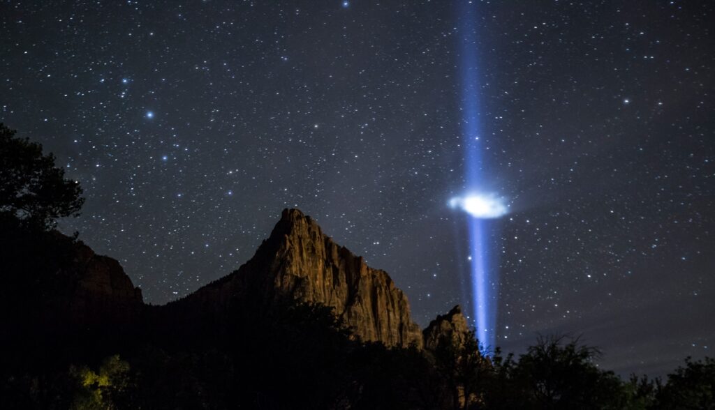 a mountain with a light in the sky