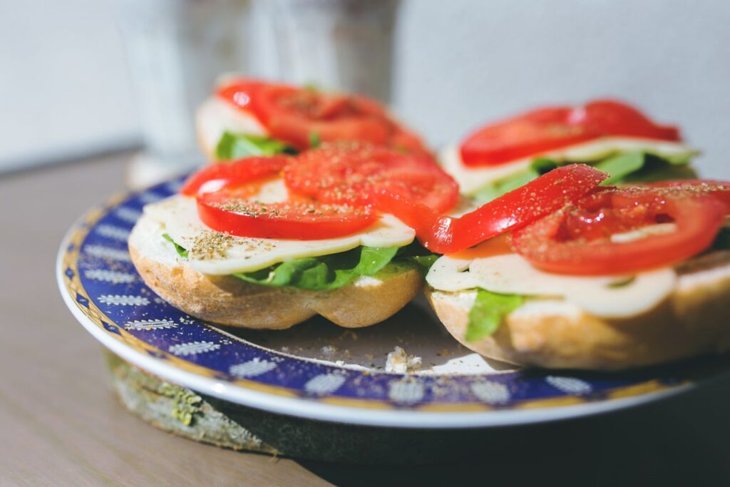 Close-up of vegetarian sandwiches with cheese, lettuce, and tomato on a decorative plate.