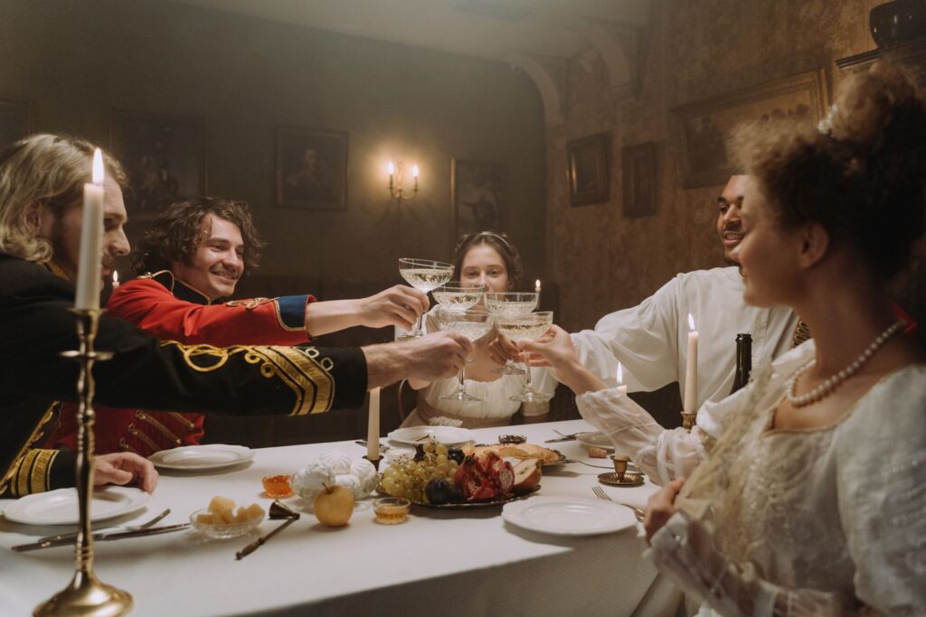 A vintage-themed dinner party with people toasting over a festive meal by candlelight.