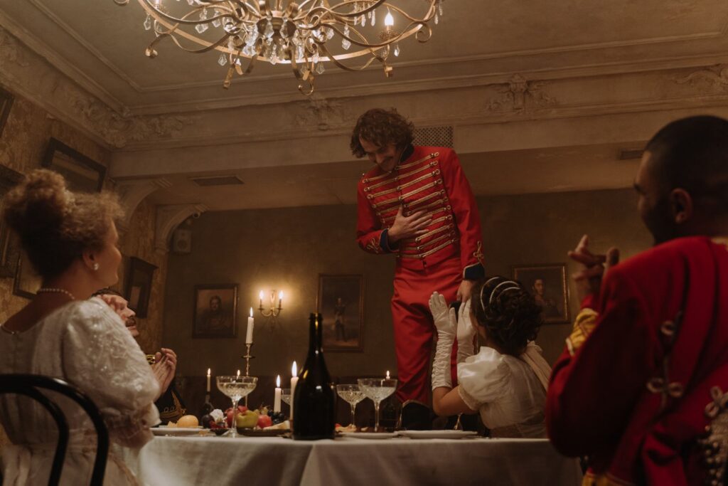 A lavish dinner party scene with elegantly dressed guests and hussars in historical attire.