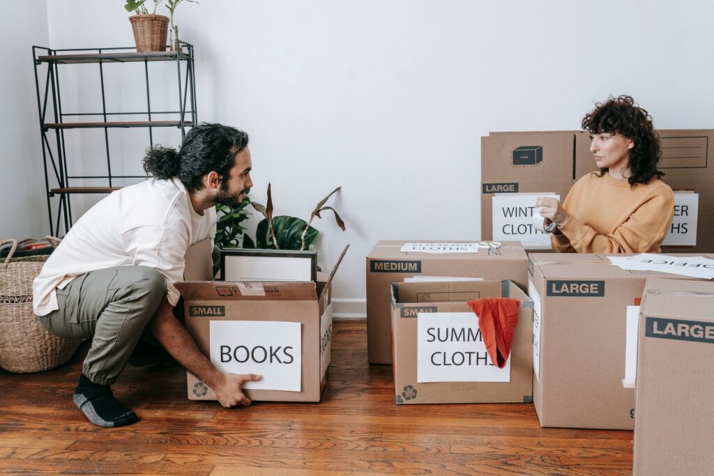 A couple sorting boxes and preparing for a move in their new home.