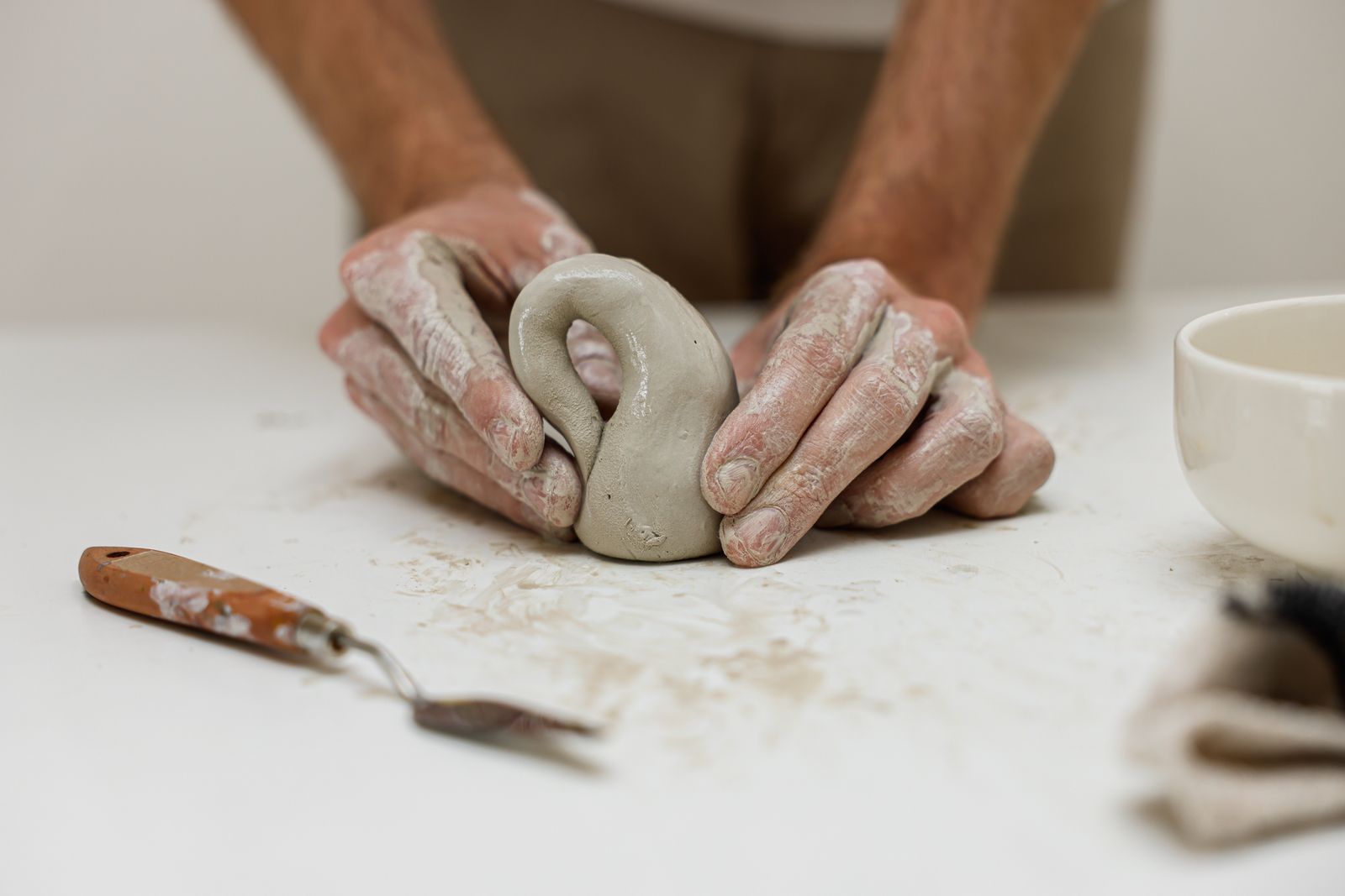A detailed view of hands skillfully shaping clay, showcasing artisanal pottery craftsmanship.