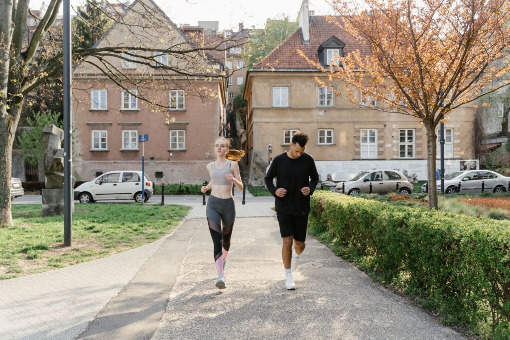 A couple jogging together in an urban park, enjoying outdoor exercise.