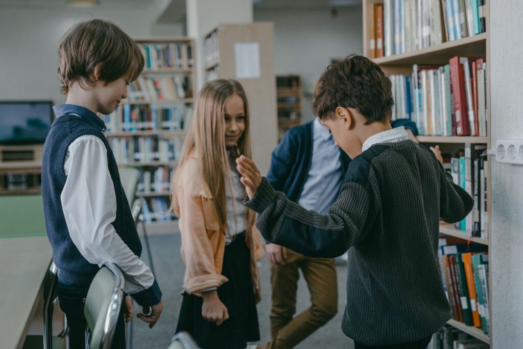 Group of children interacting in a school library, showcasing learning and friendship.