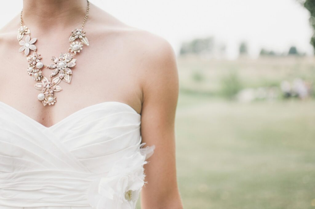woman standing in grass field with statement necklace