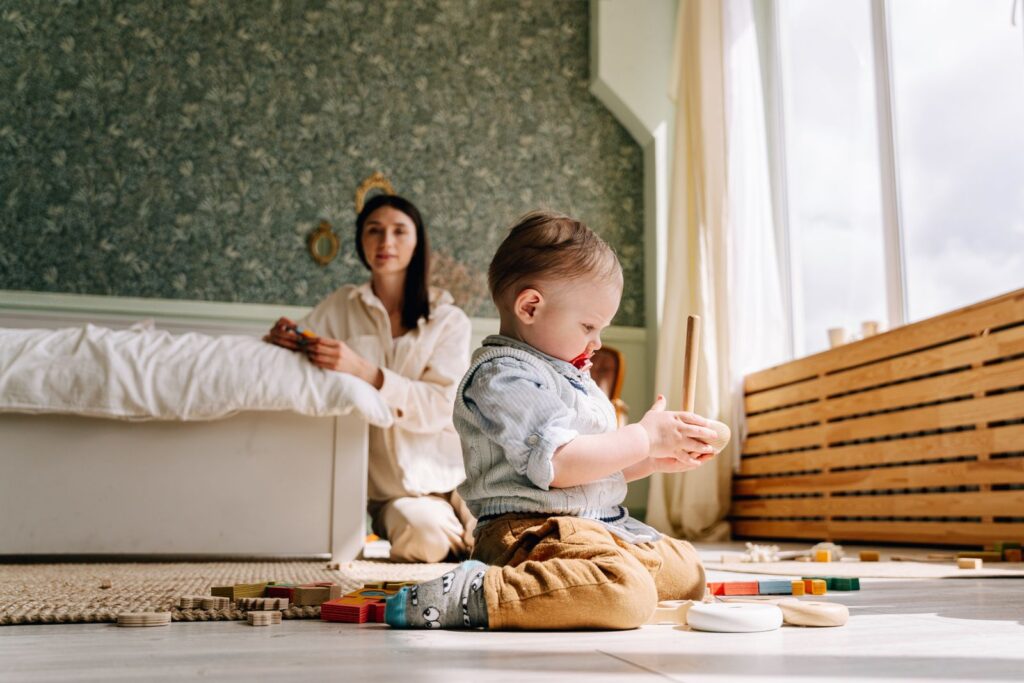 A mother and her child engage in mindful play with wooden toys in a bright, cozy room.