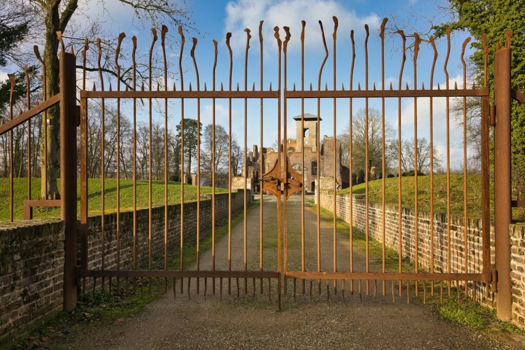 Rusty metal gate with old building in background