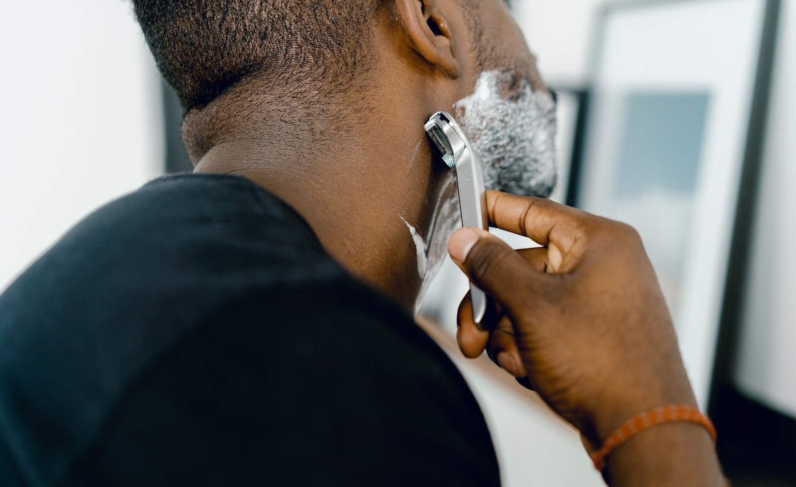Close-up of man shaving with razor